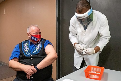 Daniel Crump / Winnipeg Free Press. Manitoba Metis Federation President David Chartrand gets a shot of the AstraZeneca COVID vaccine. Pharmacist Ayobola Ayobole-Obi administered the vaccine Saturday morning at the MEDOCare pharmacy located in the MMF building on Henry avenue in downtown Winnipeg. April 17, 2021.