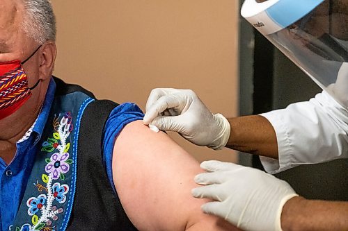 Daniel Crump / Winnipeg Free Press. Manitoba Metis Federation President David Chartrand gets a shot of the AstraZeneca COVID vaccine. Pharmacist Ayobola Ayobole-Obi administered the vaccine Saturday morning at the MEDOCare pharmacy located in the MMF building on Henry avenue in downtown Winnipeg. April 17, 2021.