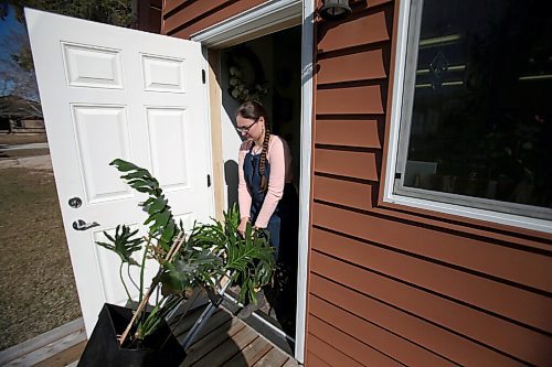 SHANNON VANRAES / WINNIPEG FREE PRESS Glass artist Heather Dawson moves a plant out of her backyard studio in Teulon on April 17, 2021.