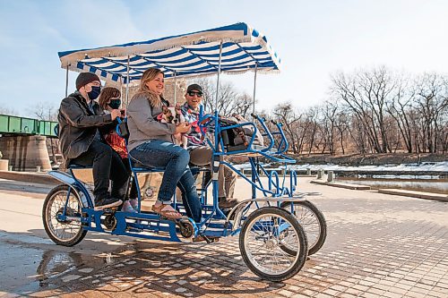 Daniel Crump / Winnipeg Free Press. The King family pedal their tandem bike rental along the path by the historic port at the Forks on a warm sunny day in downtown Winnipeg. April 17, 2021.