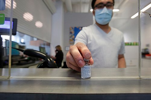 JOHN WOODS / WINNIPEG FREE PRESS
Ryan Chan, executive director of Exchange District Pharmacy, is photographed with a vial of AstraZeneca COVID-19 vaccine at his pharmacy in Winnipeg Tuesday, April 20, 2021. 

Reporter: Rollason