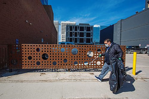MIKE DEAL / WINNIPEG FREE PRESS
Hector Felix from Barrens River FN makes his way down Smith Street picking up litter. He saw volunteers picking up trash near the park he takes his kid when they are in Winnipeg, so, he decided to ask if he could help out during the Downtown Winnipeg BIZ's annual Earth Day CleanUp Wednesday morning.
Around 60 employees from downtown businesses and community-members picked up litter in small, distanced groups spread throughout downtown during the Downtown Winnipeg BIZ's annual Earth Day CleanUp Wednesday morning. 
210421 - Wednesday, April 21, 2021.
