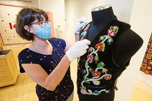 MIKE DEAL / WINNIPEG FREE PRESS
Curator Andrea Reich of the Manitoba Crafts Museum and Library straightens a beaded Métis vest on display in the gallery.
See Brenda Suderman story
210421 - Wednesday, April 21, 2021.