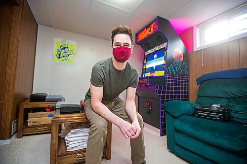 MIKAELA MACKENZIE / WINNIPEG FREE PRESS

Adam Delbridge, who built an vintage arcade video game cabinet and also repairs and modifies retro gaming consoles, poses for a portrait in his basement in Winnipeg on Wednesday, April 21, 2021. For Declan story.
Winnipeg Free Press 2020.