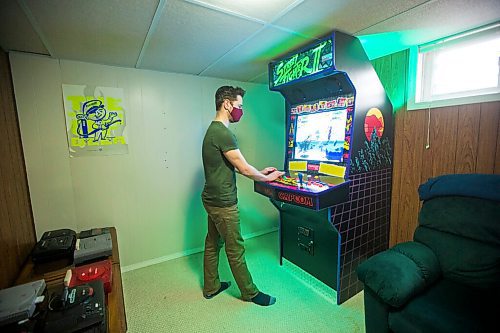MIKAELA MACKENZIE / WINNIPEG FREE PRESS

Adam Delbridge, who built an vintage arcade video game cabinet and also repairs and modifies retro gaming consoles, demonstrates the arcade game in his basement in Winnipeg on Wednesday, April 21, 2021. For Declan story.
Winnipeg Free Press 2020.