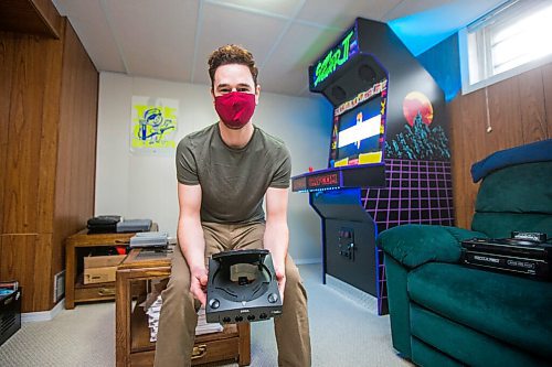 MIKAELA MACKENZIE / WINNIPEG FREE PRESS

Adam Delbridge, who built an vintage arcade video game cabinet and also repairs and modifies retro gaming consoles, poses for a portrait in his basement in Winnipeg on Wednesday, April 21, 2021. For Declan story.
Winnipeg Free Press 2020.