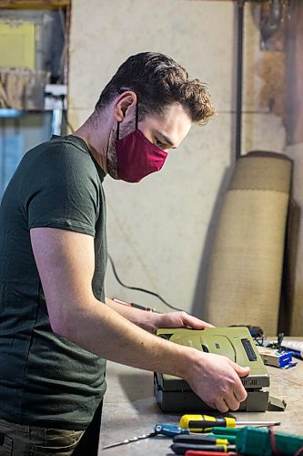 MIKAELA MACKENZIE / WINNIPEG FREE PRESS

Adam Delbridge, who built an vintage arcade video game cabinet and also repairs and modifies retro gaming consoles, opens a console up in his basement workshop in Winnipeg on Wednesday, April 21, 2021. For Declan story.
Winnipeg Free Press 2020.