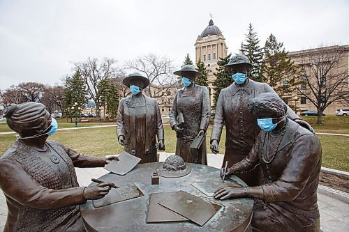 MIKE DEAL / WINNIPEG FREE PRESS
As the province heads into another round of more stringent restrictions someone has put PPE masks on the monument to the Famous Five located on the ground of the Manitoba Legislative building Monday morning. (from left) Henrietta Muir Edwards, Emily Murphy, Irene Parlby, Louise McKinney and Nellie McClung.
210426 - Monday, April 26, 2021.