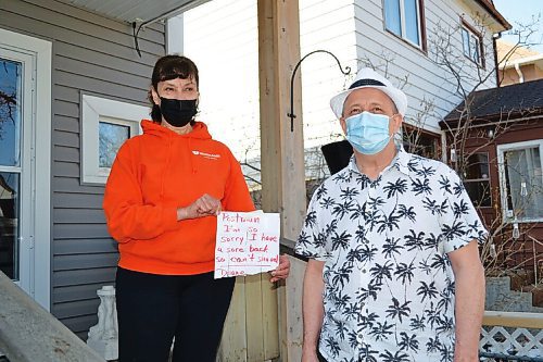 Canstar Community News Diane Bourbonnais shows off the note of apology she wrote for her postman and flyer carrier after the late-season snowfall two weeks ago. Lance carrier Ed Laberge (right) took it upon himself to clear Bourbonnais steps for her.