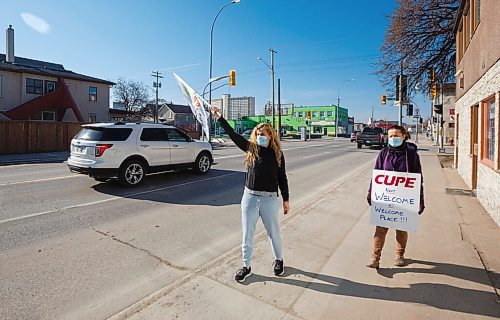 MIKE DEAL / WINNIPEG FREE PRESS
Welcome Place employees, Valentina Cerka (left) and Flora Aruna (right) walk along Isabel Street with flags and placards after being locked out of work at Welcome Place Tuesday morning.
Valentina has been working at Welcome Place for the last 22 years, while Flora has been at Welcome Place for 19 years.
Employee's of Welcome Place came to work Tuesday morning to find the doors were locked. Their union representative, Scott Clark, was on hand to start a picket line as soon as the lockout started.
210427 - Tuesday, April 27, 2021.