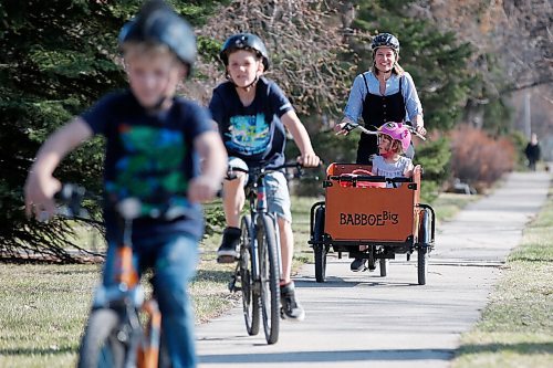 JOHN WOODS / WINNIPEG FREE PRESS
Meghan Cameron photographed with her children, left to right, Magnus, Griffin and Beatrix as they ride their bikes outside their home in Winnipeg Tuesday, April 27, 2021. Cameron and her family invested in a cargo bike, which she used to transport her children and to pick up groceries. The Camerons also compost and are trying to be more green.

Reporter: Sabrina