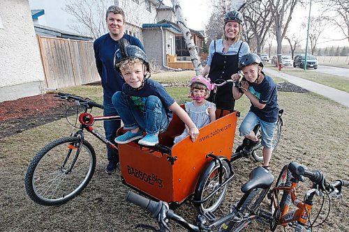 JOHN WOODS / WINNIPEG FREE PRESS
Meghan and Justin Cameron photographed with their children, left to right, Magnus, Beatrix and Griffin and their cargo bike outside their home in Winnipeg Tuesday, April 27, 2021. The Camerons invested in a cargo bike, which they used to transport their children and to pick up groceries. The Camerons also compost and are trying to be more green.

Reporter: Sabrina