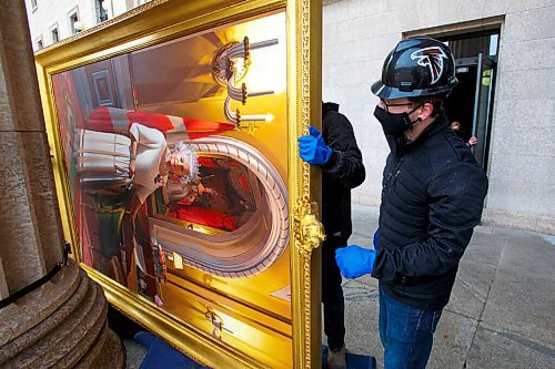 MIKE DEAL / WINNIPEG FREE PRESS
Forman Ryland Warren makes sure everything is good to go before taking the painting into the building. 
A crew from Total Co-ordination and Construction unloads and installs the Diamond Jubilee Portrait of Her Majesty Queen Elizabeth II which is on a cross country tour while Rideau Hall in Ottawa where it is normally on display undergoes construction. The painting will be in the Manitoba Legislative building room 200 for a year, until May 2022.
The portrait, which is part of the NCCs Crown Collection, was painted on the occasion of Her Majesty Queen Elizabeth IIs Diamond Jubilee by Phil Richards. It was officially unveiled in London, U.K., in 2012, in the presence of The Queen, the Right Honourable David Johnston, then-Governor General of Canada, and the Right Honourable Stephen Harper, then-Prime Minister of Canada. The painting was installed at Rideau Hall on June 28, 2012. That same year, it was the subject of a documentary produced by the National Film Board of Canada to show the various steps involved in creating the portrait and interviews with the artist. 
In late 2018, The Office of the Secretary to the Governor General of Canada (OSGG) announced that the Diamond Jubilee Portrait of Her Majesty Queen Elizabeth II, which has been on display in the Ballroom at Rideau Hall since 2012, would be undertaking a cross-country tour.
Since leaving Rideau Hall in September 2018, the portrait has been on display in St. Johns, N.L., as well as Fredericton, N.B. It will remain on display at the Manitoba Legislative Building until May 2022. Her Majesty will also celebrate Her Platinum Jubilee in 2022, marking 70 years since her accession to the throne.
The portrait will not be on public display until COVID restrictions are lifted, allowing for tours of the building to resume.
210503 - Monday, May 03, 2021.