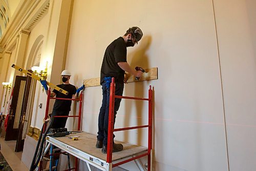 MIKE DEAL / WINNIPEG FREE PRESS
Forman Ryland Warren attaches wood that will hold the painting to the wall in Room 200 in the Manitoba Legislative building. 
A crew from Total Co-ordination and Construction unloads and installs the Diamond Jubilee Portrait of Her Majesty Queen Elizabeth II which is on a cross country tour while Rideau Hall in Ottawa where it is normally on display undergoes construction. The painting will be in the Manitoba Legislative building room 200 for a year, until May 2022.
The portrait, which is part of the NCCs Crown Collection, was painted on the occasion of Her Majesty Queen Elizabeth IIs Diamond Jubilee by Phil Richards. It was officially unveiled in London, U.K., in 2012, in the presence of The Queen, the Right Honourable David Johnston, then-Governor General of Canada, and the Right Honourable Stephen Harper, then-Prime Minister of Canada. The painting was installed at Rideau Hall on June 28, 2012. That same year, it was the subject of a documentary produced by the National Film Board of Canada to show the various steps involved in creating the portrait and interviews with the artist. 
In late 2018, The Office of the Secretary to the Governor General of Canada (OSGG) announced that the Diamond Jubilee Portrait of Her Majesty Queen Elizabeth II, which has been on display in the Ballroom at Rideau Hall since 2012, would be undertaking a cross-country tour.
Since leaving Rideau Hall in September 2018, the portrait has been on display in St. Johns, N.L., as well as Fredericton, N.B. It will remain on display at the Manitoba Legislative Building until May 2022. Her Majesty will also celebrate Her Platinum Jubilee in 2022, marking 70 years since her accession to the throne.
The portrait will not be on public display until COVID restrictions are lifted, allowing for tours of the building to resume.
210503 - Monday, May 03, 2021.