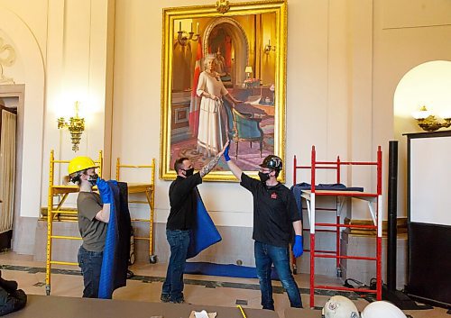 MIKE DEAL / WINNIPEG FREE PRESS
Forman Ryland Warren (right) high-fives co-worker, Thomas Hillier (left) after the painting is finally installed.
A crew from Total Co-ordination and Construction unloads and installs the Diamond Jubilee Portrait of Her Majesty Queen Elizabeth II which is on a cross country tour while Rideau Hall in Ottawa where it is normally on display undergoes construction. The painting will be in the Manitoba Legislative building room 200 for a year, until May 2022.
The portrait, which is part of the NCCs Crown Collection, was painted on the occasion of Her Majesty Queen Elizabeth IIs Diamond Jubilee by Phil Richards. It was officially unveiled in London, U.K., in 2012, in the presence of The Queen, the Right Honourable David Johnston, then-Governor General of Canada, and the Right Honourable Stephen Harper, then-Prime Minister of Canada. The painting was installed at Rideau Hall on June 28, 2012. That same year, it was the subject of a documentary produced by the National Film Board of Canada to show the various steps involved in creating the portrait and interviews with the artist. 
In late 2018, The Office of the Secretary to the Governor General of Canada (OSGG) announced that the Diamond Jubilee Portrait of Her Majesty Queen Elizabeth II, which has been on display in the Ballroom at Rideau Hall since 2012, would be undertaking a cross-country tour.
Since leaving Rideau Hall in September 2018, the portrait has been on display in St. Johns, N.L., as well as Fredericton, N.B. It will remain on display at the Manitoba Legislative Building until May 2022. Her Majesty will also celebrate Her Platinum Jubilee in 2022, marking 70 years since her accession to the throne.
The portrait will not be on public display until COVID restrictions are lifted, allowing for tours of the building to resume.
210503 - Monday, May 03, 2021.