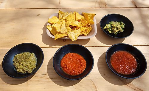 MIKE DEAL / WINNIPEG FREE PRESS
Nachos chips with a variety of sides; (clockwise) guacamole, salsa ranchera, salsa roja, and salsa verde.
The Beer Cantina is a Mexican-inspired food stand offering food made with local ingredients to patrons of the patio. Local chef Keith Csabak is leading the endeavour and there will be more cooks in the kitchen during regular pop-ups. This is a step up from the food truck they partnered with last year.
210504 - Tuesday, May 04, 2021.