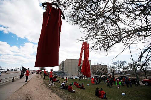 JOHN WOODS / WINNIPEG FREE PRESS
Red dresses swing from the trees as people gather to remember Murdered and Missing Indigenous Women and Girls (MMIWG) at the corner of Salter and Dufferin and to tie ribbons with names of MMIWG on the Slaw Rebchuck Bridge Wednesday, May 5, 2021. 

Reporter: ?
