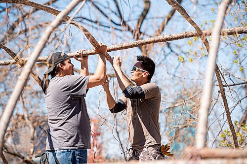 MIKE SUDOMA / WINNIPEG FREE PRESS  
(Left to right) Kirby Nelson and Andrew Atkinson tie together the structure of a traditional midewiwin lodge on the river banks across from the Forks Market Friday afternoon. 
May 7, 2021