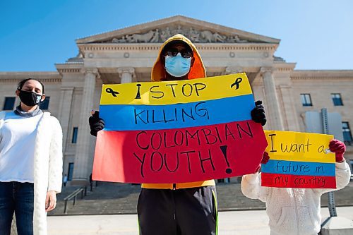 Daniel Crump / Winnipeg Free Press. A protestors hold signs during a rally calling for an end to the violence against protestors in Colombia. Simultaneous rallied were held at the Canadian Museum for Human Rights and the Manitoba Legislature as well as a vehicle rally that looped between the two locations. May 8, 2021.