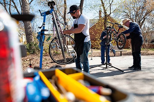 Daniel Crump / Winnipeg Free Press. Will Bedford (left) works on a bike at a park near Laura Secord School in Wolesely on Saturday afternoon. Bedford and his friend John Andersen (right) decided to undertake this act of community service to boost peoples spirits and help get more cyclists on the road this summer. May 8, 2021.