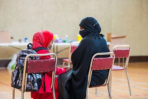 MIKAELA MACKENZIE / WINNIPEG FREE PRESS

Kuresha Mohamed and her daughter wait for the 15 minute observation period to end after getting her COVID-19 vaccine at a pop-up community vaccine clinic at Knox United Church in Winnipeg on Friday, May 14, 2021. For JS story.
Winnipeg Free Press 2020.