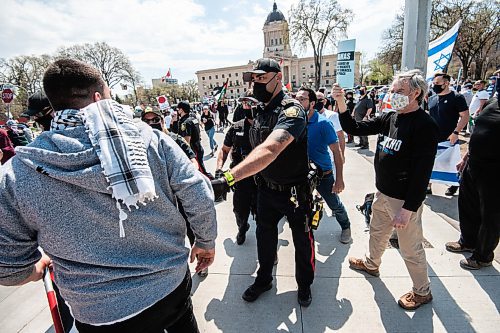 MIKE SUDOMA / WINNIPEG FREE PRESS  
Police hold back a Palestinian protester back who was being taunted by Israeli protesters Saturday afternoon