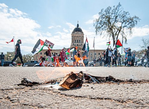 MIKE SUDOMA / WINNIPEG FREE PRESS  
A stolen Israeli flag lies on the ground in flames after Palestinian protesters set it ablaze Saturday afternoon
May 15, 2021