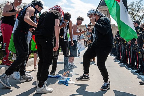 MIKE SUDOMA / WINNIPEG FREE PRESS  
Palestinian protesters burn and stomp on a flag stolen from an Israeli protester during a rally in memorial park in downtown Winnipeg Saturday afternoon 
May 15, 2021