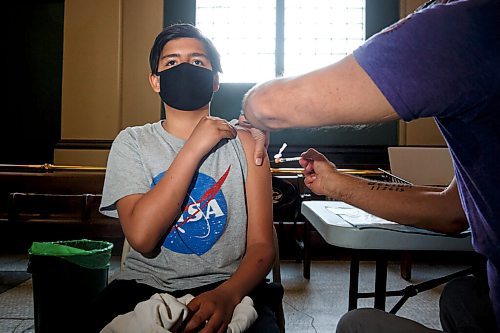 MIKE DEAL / WINNIPEG FREE PRESS
Dr. Barry Lavallee, CEO, Keewatinowi Inniniw Minoayawin, administers the Pfizer-BioNTech vaccine to Sam Hallett, 12, at the Aboriginal Health and Wellness Centre, 181 Higgins Ave., Winnipeg, early Monday morning.
210517 - Monday, May 17, 2021.