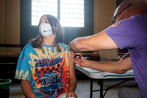 MIKE DEAL / WINNIPEG FREE PRESS
Dr. Barry Lavallee, CEO, Keewatinowi Inniniw Minoayawin, administers the Pfizer-BioNTech vaccine to Cassidy MacPherson, 13, at the Aboriginal Health and Wellness Centre, 181 Higgins Ave., Winnipeg, early Monday morning.
210517 - Monday, May 17, 2021.