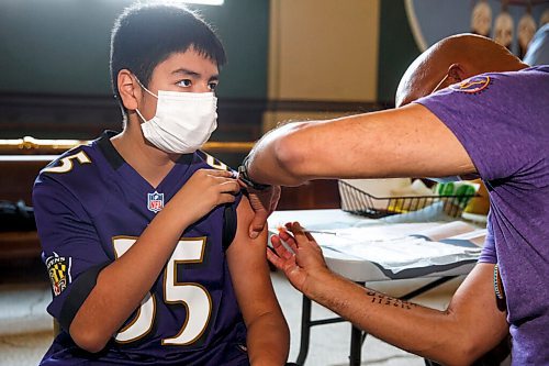 MIKE DEAL / WINNIPEG FREE PRESS
Dr. Barry Lavallee, CEO, Keewatinowi Inniniw Minoayawin, administers the Pfizer-BioNTech vaccine to Alexander Herrera, 14, at the Aboriginal Health and Wellness Centre, 181 Higgins Ave., Winnipeg, early Monday morning.
210517 - Monday, May 17, 2021.