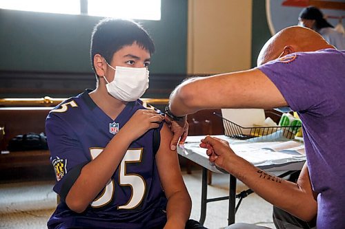 MIKE DEAL / WINNIPEG FREE PRESS
Dr. Barry Lavallee, CEO, Keewatinowi Inniniw Minoayawin, administers the Pfizer-BioNTech vaccine to Alexander Herrera, 14, at the Aboriginal Health and Wellness Centre, 181 Higgins Ave., Winnipeg, early Monday morning.
210517 - Monday, May 17, 2021.