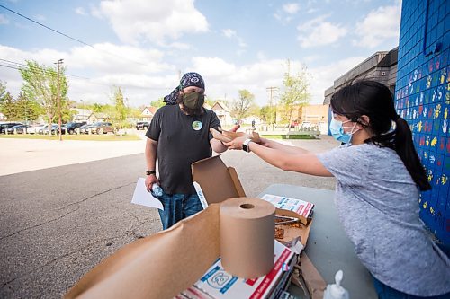 MIKAELA MACKENZIE / WINNIPEG FREE PRESS

Liliene Balmediano serves pizza to Jeremy Klassen after getting his shot at a pop-up vaccination site at Weston Community Centre in Winnipeg on Tuesday, May 18, 2021. The team has given out over 200 Moderna vaccines over the four days of community-based clinics. Standup.
Winnipeg Free Press 2020.