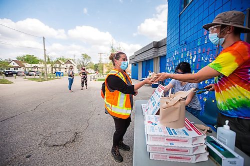 MIKAELA MACKENZIE / WINNIPEG FREE PRESS

Liliene Balmediano and Craig Krochak serve pizza to Tina Beardy after her shot at a pop-up vaccination site at Weston Community Centre in Winnipeg on Tuesday, May 18, 2021. The team has given out over 200 Moderna vaccines over the four days of community-based clinics. Standup.
Winnipeg Free Press 2020.