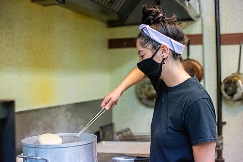 MIKAELA MACKENZIE / WINNIPEG FREE PRESS

Carter Bouchard, owner of Salt and Sunshine Bagels (a specialty bagel bakery she started on Instagram during the pandemic), whips up a batch of sesame bagels in her rented kitchen space at the Irish Association in Winnipeg on Thursday, May 20, 2021.  For Eva Wasney story.
Winnipeg Free Press 2020.