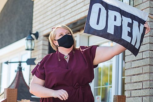 MIKAELA MACKENZIE / WINNIPEG FREE PRESS

Pennyweight Market co-owner Kim Friesen puts out an open sign at the shop in Beausejour on Thursday, May 27, 2021. For Dave Sanderson story.
Winnipeg Free Press 2020.