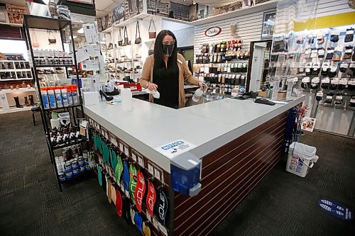 JOHN WOODS / WINNIPEG FREE PRESS
Kayla Johnson disinfects the checkout area at Canadian Footwear in Winnipeg Thursday, May 27, 2021. COVID-19 restrictions have been extended. 

Reporter: Durrani