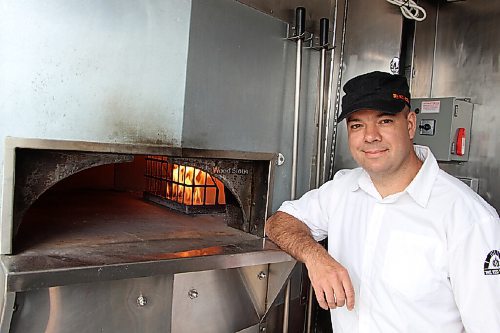 Canstar Community News Steffen Zinn, owner of food truck The Red Ember, stands beside the truck's oven on May 26. (GABRIELLE PICHÉ/CANSTAR COMMUNITY NEWS/HEADLINER)