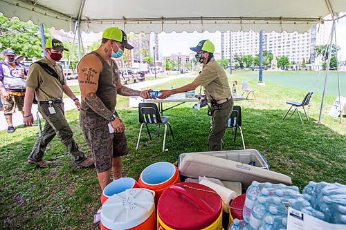 MIKAELA MACKENZIE / WINNIPEG FREE PRESS

Vincent Lillie hands a bottle to Kimberly Kostiuk as they hand out free water to folks at Central Park in Winnipeg on Friday, June 4, 2021. For Cody Sellar story.
Winnipeg Free Press 2021.