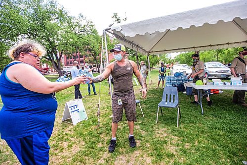 MIKAELA MACKENZIE / WINNIPEG FREE PRESS

Vincent Lillie, with the DCSP, gives free water to Amanda St. Germaine at Central Park in Winnipeg on Friday, June 4, 2021. For Cody Sellar story.
Winnipeg Free Press 2021.