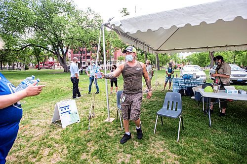 MIKAELA MACKENZIE / WINNIPEG FREE PRESS

Vincent Lillie, with the DCSP, gives free water to Amanda St. Germaine at Central Park in Winnipeg on Friday, June 4, 2021. For Cody Sellar story.
Winnipeg Free Press 2021.