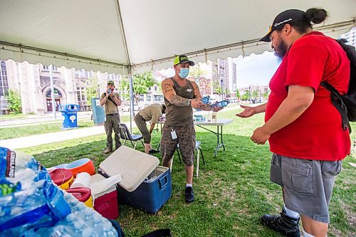 MIKAELA MACKENZIE / WINNIPEG FREE PRESS

Vincent Lillie, with the DCSP, gives free water to folks at Central Park in Winnipeg on Friday, June 4, 2021. For Cody Sellar story.
Winnipeg Free Press 2021.