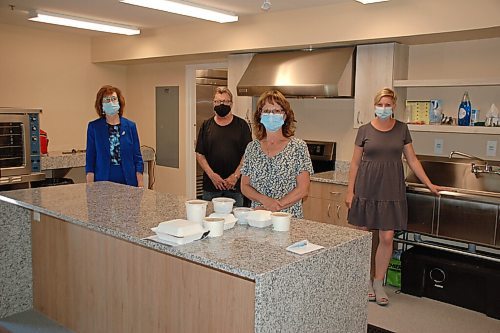 Canstar Community News From left: Colleen Tackaberry, Stephen Hetherington, Bernadette Ermel and Stacy Boone prepare for a meal pick-up in the kitchen at the 500 Widlake seniors' residence in Transcona.