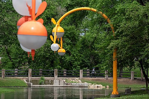 ALEX LUPUL / WINNIPEG FREE PRESS  

People walk along the water at Kildonan Park in Winnipeg on Wednesday, June 9, 2021. Takashi Iwasaki's art, entitled Bokeh, can be seen in the foreground.