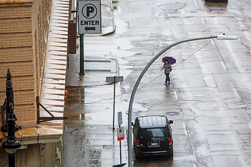 MIKE DEAL / WINNIPEG FREE PRESS
A wet Smith Street gleams while an umbrella toting pedestrian hurries towards their destination Wednesday afternoon.
210609 - Wednesday, June 09, 2021.