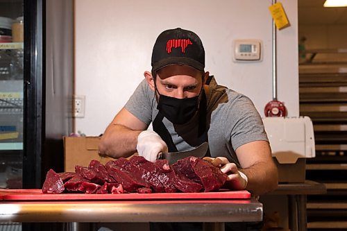 MIKE SUDOMA / WINNIPEG FREE PRESS
Mr Bitlong owner, Jeremy Silcox, cuts up a large hunk of meat as he gets ready to make another batch of biltong Tuesday evening
June 9, 2021