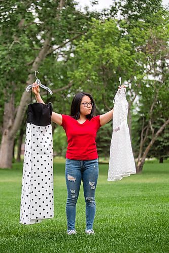 MIKAELA MACKENZIE / WINNIPEG FREE PRESS

SJR student Lauren McIlroy poses for a portrait holding the two dresses that she was excited to wear to grad events that have been cancelled at her home in La Salle on Thursday, June 10, 2021. For Jen story.
Winnipeg Free Press 2021.