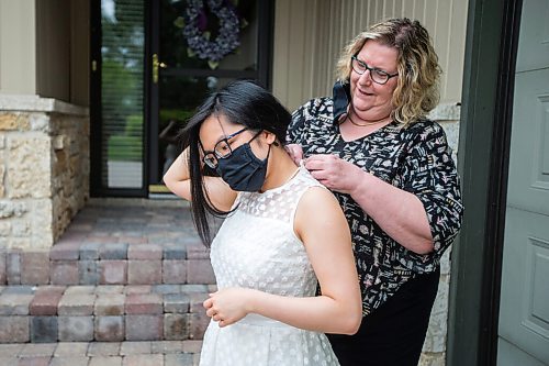 MIKAELA MACKENZIE / WINNIPEG FREE PRESS

Lauren McIlroy's mom helps her get her dress done up before posing for a portrait (in one of the two dresses that she was excited to wear to grad events that have been cancelled) at her home in La Salle on Thursday, June 10, 2021. For Jen story.
Winnipeg Free Press 2021.