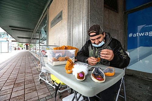 RUTH BONNEVILLE / WINNIPEG FREE PRESS

ENT - Moccasin artist at The Bay

Portrait of local indigenous artist, Jemmy Mckenzie, sewing together baby moccasins at a small table in front of The Bay downtown on Thursday 

See Reporter: Ben Waldman's story on WAG and the Hudson Bay store windows.  

June 10,, 2021

