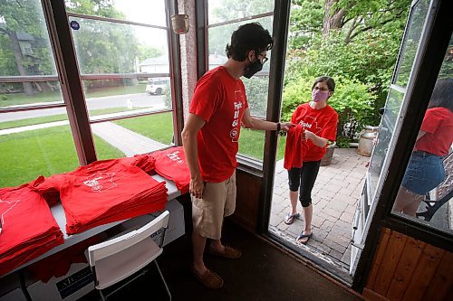 JOHN WOODS / WINNIPEG FREE PRESS
Rural teacher Kara Godin picks up a t-shirt from Aaron Beckman, a Winnipeg resource teacher and member of Protect EdMB who organizes and distributes red t-shirts in his sunroom, Thursday, June 10, 2021. Beckman oversees the Protect EdMB Red For Ed t-shirt campaign which speaks out about the provincial governments Bill 64, which overhauls K-12 education, and also raises money for school breakfast and lunch programs.

Reporter: Macintosh